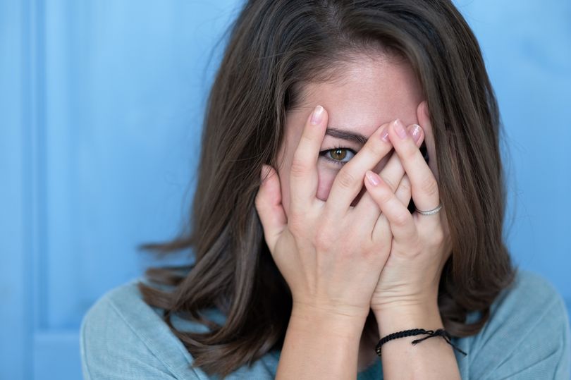 Studio-shot-of-brunette-girl-hiding-eyes-under-hand-while-feeling-ashamed.jpg