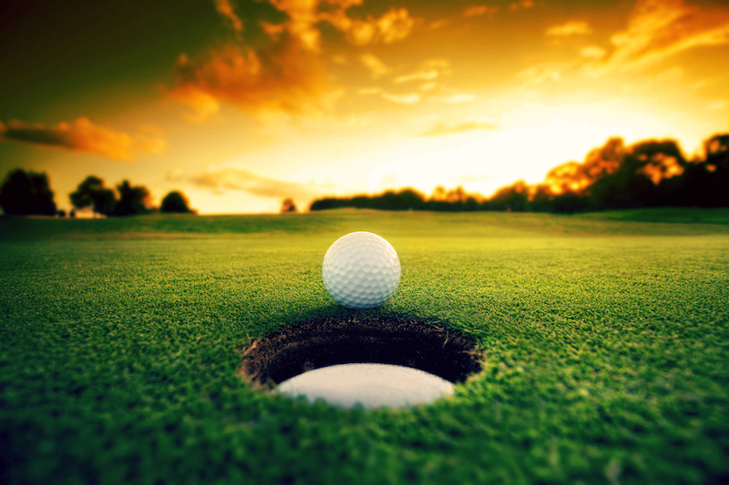 Golf_Golf ball about to fall into the cup at sunset.jpg