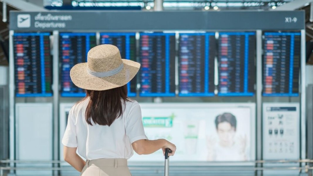 young-woman-hand-holding-luggage-handle-before-checking-flight-time-airpor-1024x576.jpg