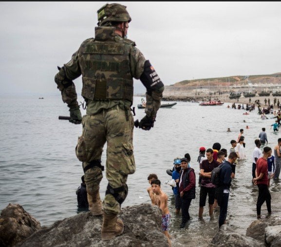 Migrants overwhelm Spanish border, troops deployed, fires burn